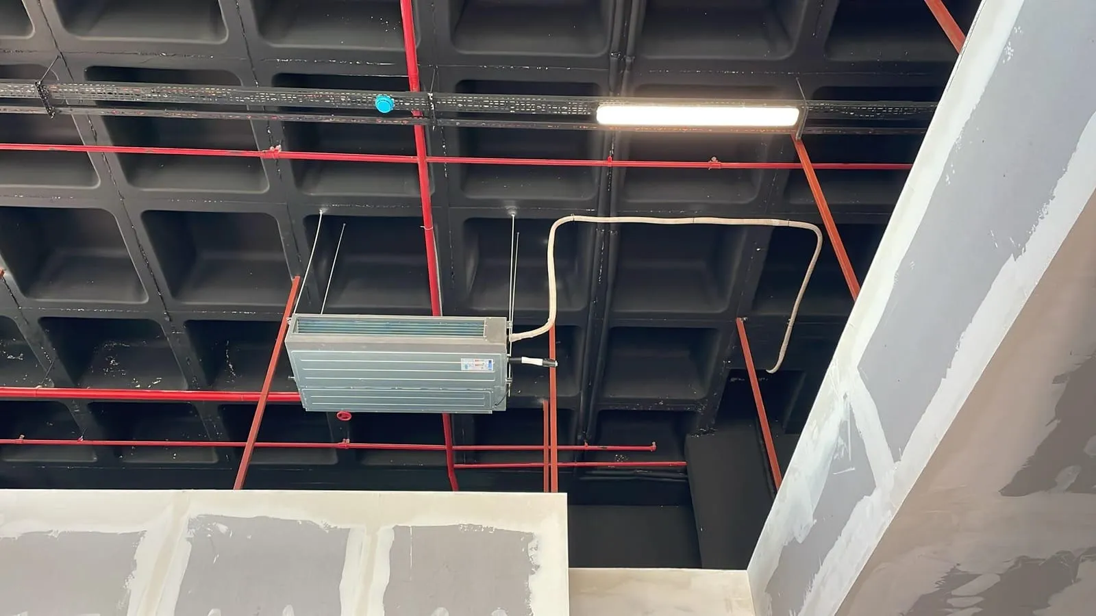Kırmızı yangın hatlarının geçtiği kaset tavanda klima ünitesi ve lineer armatür