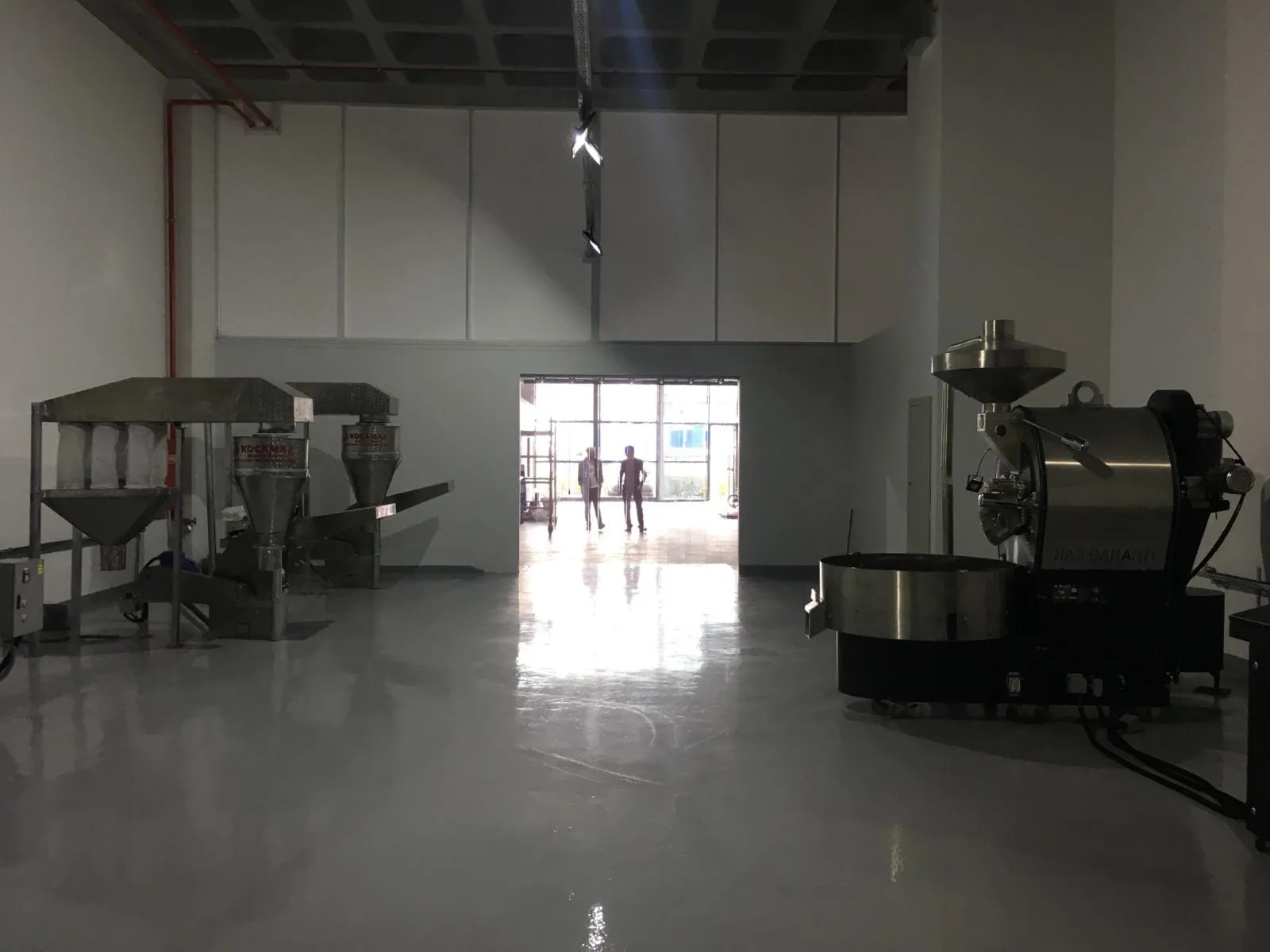 Epoksi zeminli üretim alanında makineler ve tavan aydınlatması