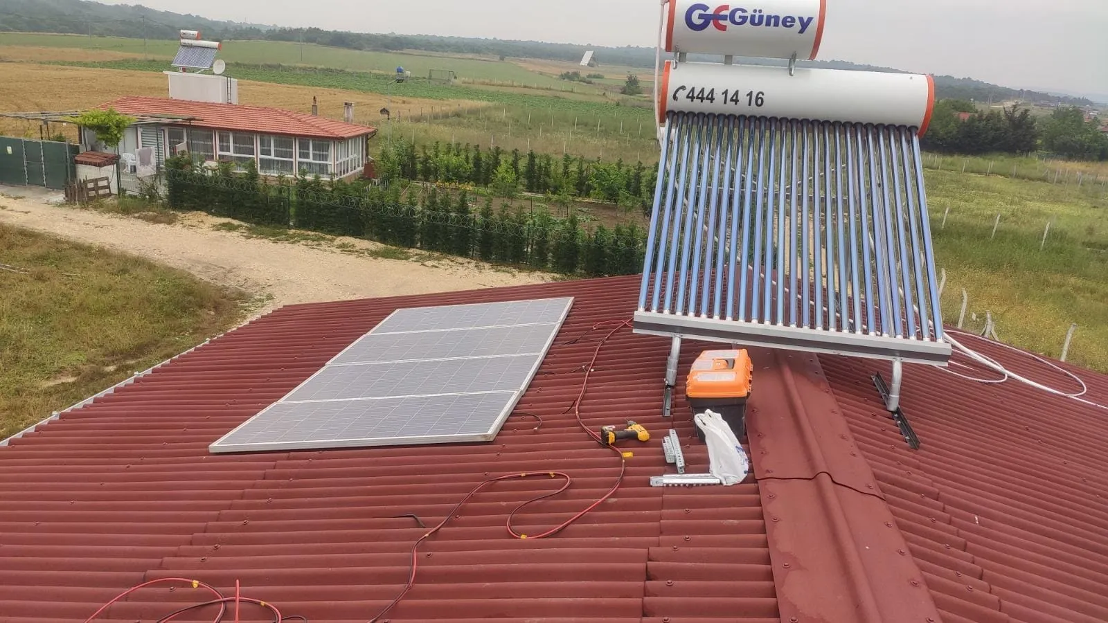 Çatıya kurulan güneş paneli ve güneş enerjili su ısıtıcısı, arkada Çatalca arazisi