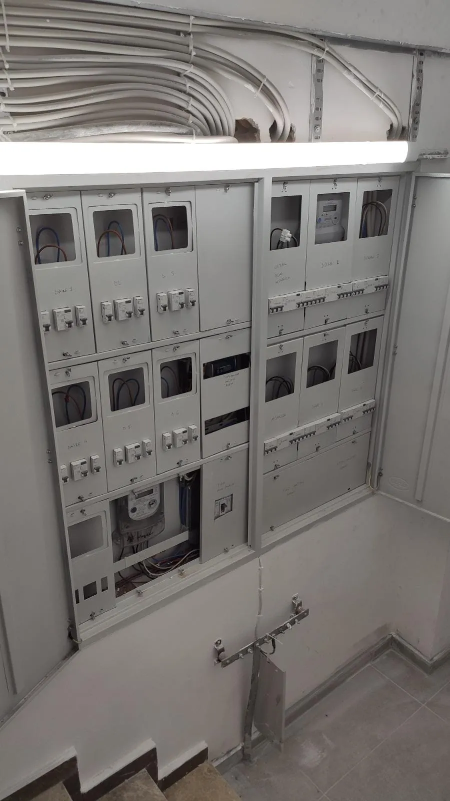 Apartman sayaç odasında sayaç panoları ve üstten gelen kablo demetleri