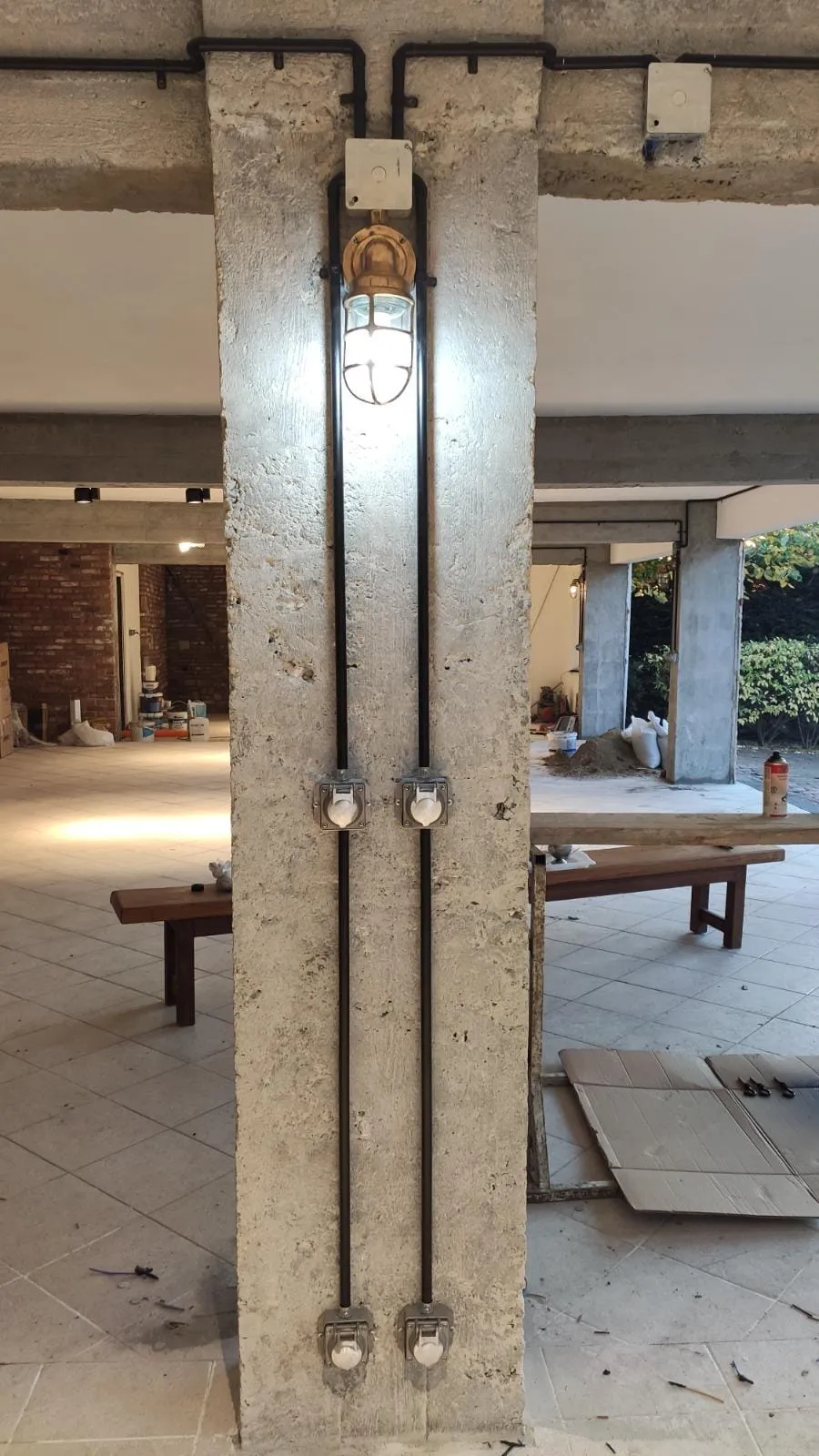 Brüt beton kolon üzerinde dikey boru hatları ve priz kutuları